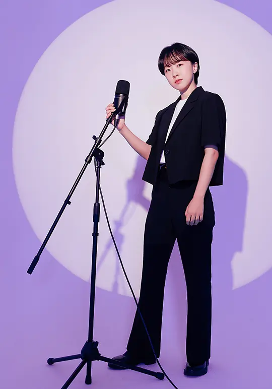 Dabin Cha standing in a black suit next to a microphone